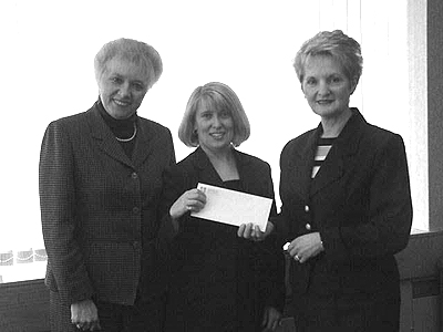 Labour Minister Anna Thistle (right), presents a cheque for $3,500 on behalf of the department