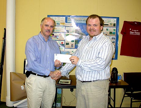 Environment and Conservation Minister Tom Osborne presents a cheque to Terry McNeil, director of the Newfoundland and Labrador Conservation Corps.