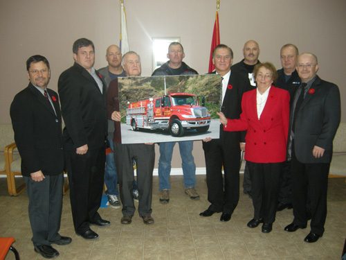 The Honourable Kevin O'Brien, Minister of Municipal Affairs and Minister responsible for Fire and Emergency Services - Newfoundland and Labrador, and Tony Cornect, MHA for Port au Port, unveil a picture of a new four-door pumper truck for the Port au Port Fire Department.  Also involved in the announcement were Mayor Eileen Hann of Port au Port East, Mayor Bryan Bennett of Port au Port-Aguathuna-Felix Cove, other community leaders and members of the fire department – November 9, 2012.