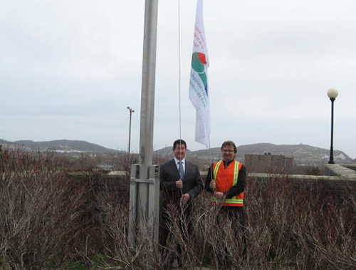 The Honourable Nick McGrath, Minister of Service NL, raises the North American Occupational Safety and Health Week flag with Mr. Mark Balsom, Chair of the Newfoundland and Labrador Chapter of the Canadian Society of Safety Engineers