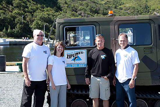 Ron Doyle, Mayor of Petty Harbour, the Honourable 
	Charlene Johnson, Minister of Child, Youth and Family Services, Rob Carter, owner of 
	North Atlantic Ziplines, and the Honourable Keith Hutchings, Minister of Innovation, Business
	and Rural Development, pose in front of the company’s Hugland Tour Bus.